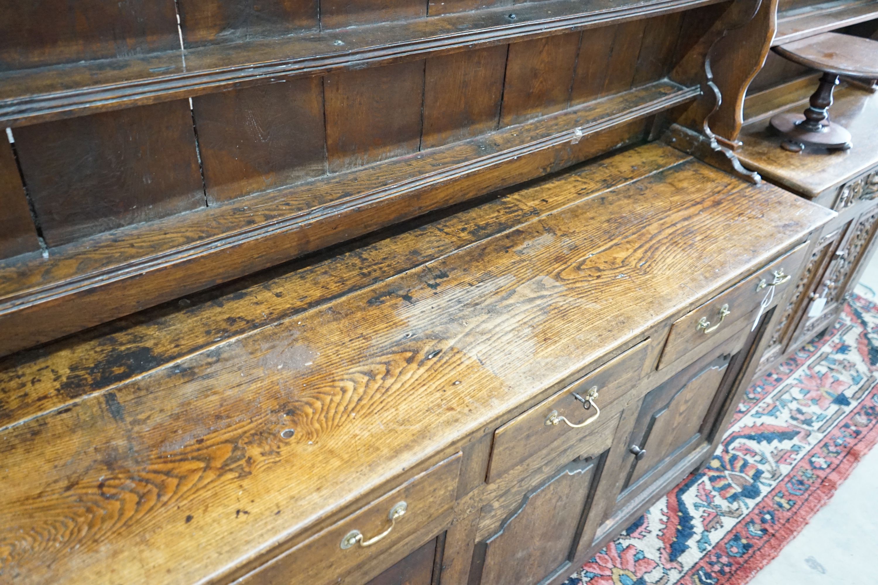 An 18th century oak dresser with boarded rack, length 172cm, depth 50cm, height 198cm